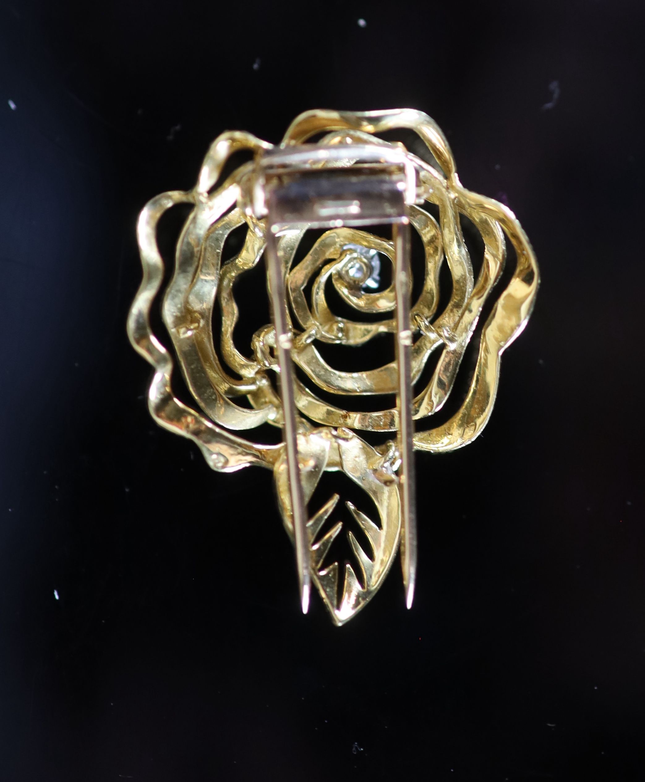 A 1980's French Cartier textured 18ct gold and diamond set 'open rose' clip brooch